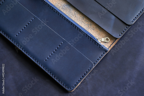 Open black leather wallet on a gray background. View from above.