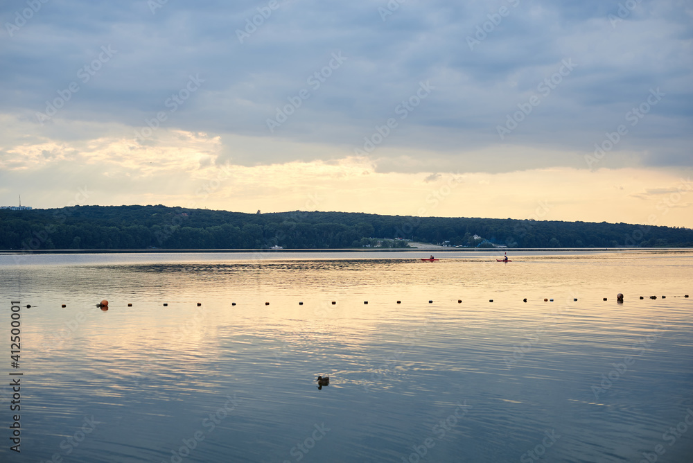 Naklejka premium Amazing lake landscape in the evening. Blue yellow cloudy sky with reflection in water at sunset. Nature protection concept. Rural scene in countryside. Ecological conservation.Eco tourism development