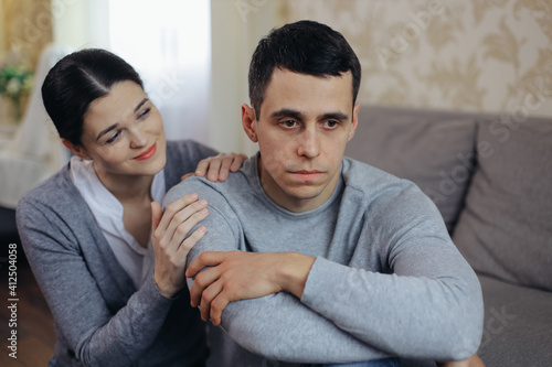 A woman comforts a sad man. Family support