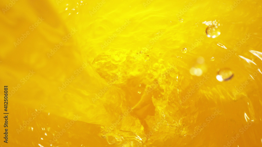 Detail of pouring orange juice in twister, freeze motion Detail of pouring orange juice in twister, freeze motion