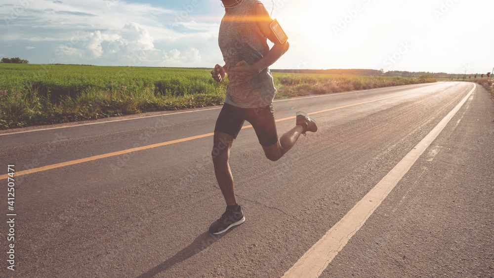 Low Section Of Man Running On Road Against Sky - obrazy, fototapety, plakaty 