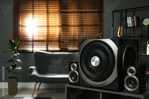 Modern audio speaker system on wooden table in living room