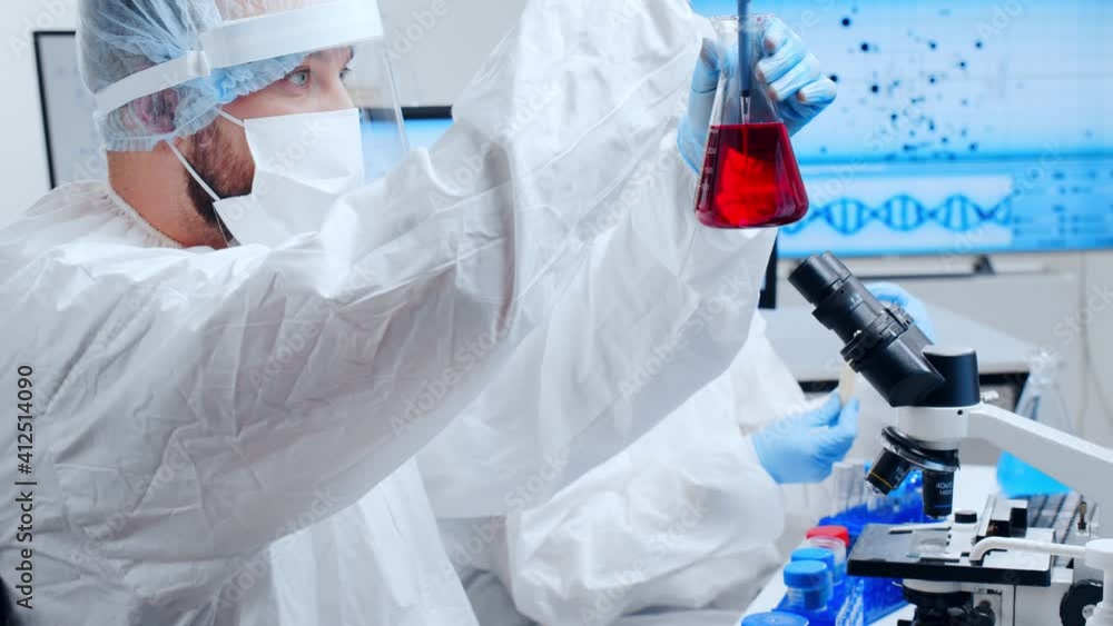 Professional team of scientists is working on a vaccine in a modern scientific research laboratory. Genetic engineer workplace. Future technology and science. Professional team of scientists is working on a vaccine in a modern scientific research laboratory. Genetic engineer workplace. Future technology and science.