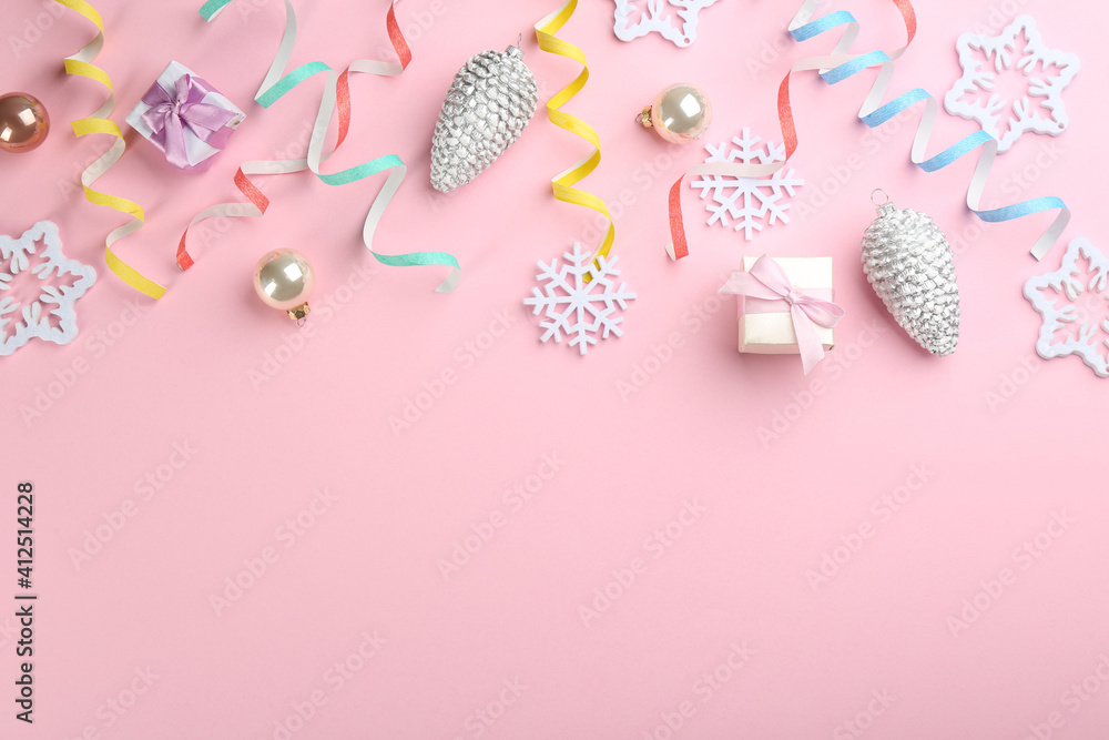 Flat lay composition with serpentine streamers and Christmas decor on pink background. Space for text Flat lay composition with serpentine streamers and Christmas decor on pink background. Space for text