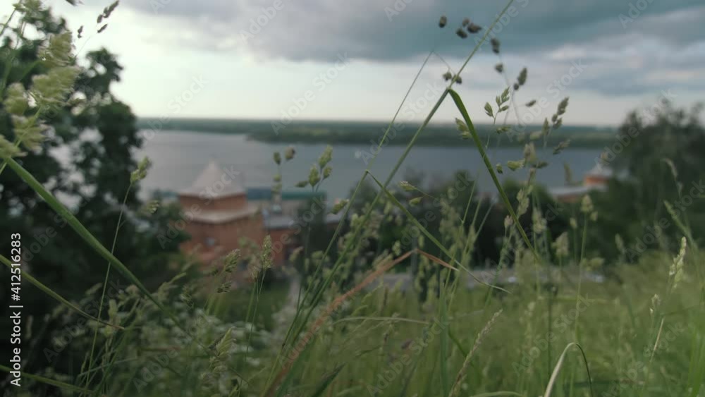 Views of the Volga and towers of the Nizhny Novgorod Kremlin in summer, the beauty of nature in the city, the wind swaying grass and trees Views of the Volga and towers of the Nizhny Novgorod Kremlin in summer, the beauty of nature in the city, the wind swaying grass and trees