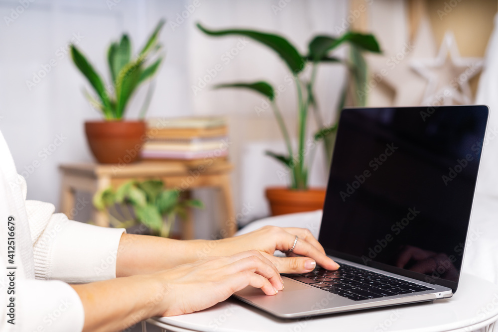 Freelance woman typing at laptop and online shopping, near the plants. Happy girl woking from home office. Distance learning online education and work. Freelance woman typing at laptop and online shopping, near the plants. Happy girl woking from home office. Distance learning online education and work.