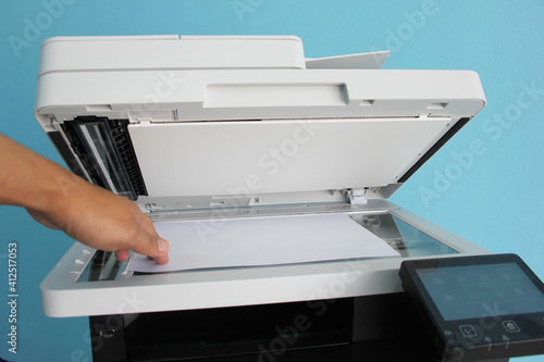 Bussiness man Hand press button on panel of printer, printer scanner laser office copy machine supplies start concept.