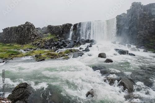 Oksararfoss Falls in Tingvellir National Park in Iceland. cloudy weather and water dust. Epic view and look. concept of research and travel in the Scandinavian countries. Fresh air and pristine nature © Artem