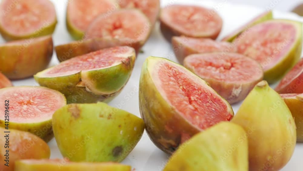 Zoom in view of slices of figs on a white table Zoom in view of slices of figs on a white table