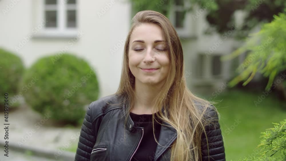 Face of young woman in the garden who is gently smiling while having her eyes closed. She's thinkingh about something nice. Face of young woman in the garden who is gently smiling while having her eyes closed. She's thinkingh about something nice.