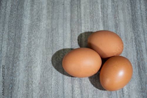 Fresh farm eggs on a rustic wooden background.