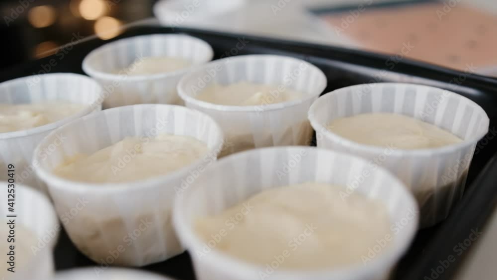 Step by step. Scoop the muffin batter into the muffin tray to bake the vanilla muffins. Confectioner preparing pastries in the kitchen Step by step. Scoop the muffin batter into the muffin tray to bake the vanilla muffins. Confectioner preparing pastries in the kitchen