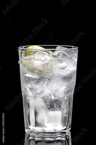 Carbonated water with ice cubes and lemon