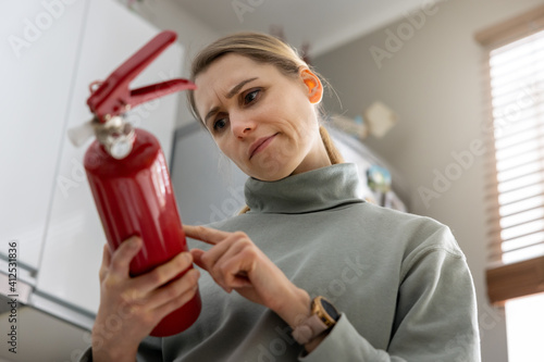 Canvastavla woman check the fire extinguisher expiration date at home
