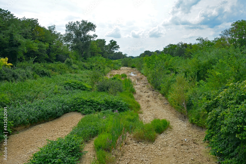 The dried up river bed of the Torrente Malina in rural Friuli-Venezia Giulia, north east Italy, near Cividale del Friuli. It is often totally dry and filled with vegetation during the summer
