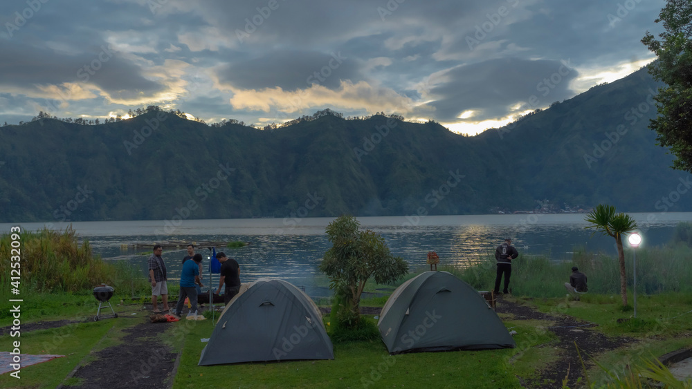 Camping beside Batur Lake with beautiful Mountain and sunrise View in Bali