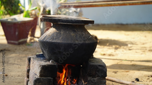 Pottery with wood stove on traditional kitchen native country of India. Natural clay stove or brick stove with wooden sticks. photo