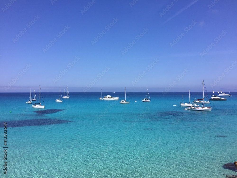 Barcos y yates fondeados en Cala Saona de Formentera con el mar azul turquesa