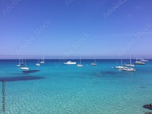 Barcos y yates fondeados en Cala Saona de Formentera con el mar azul turquesa photo