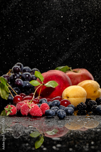 Summer fresh berries and fruits on black background