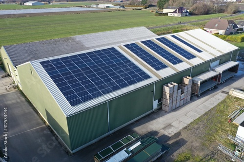 Flower bulb company with solar panels in a row on a roof. Photo taken with a drone photo