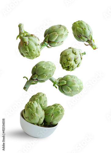 Flying artichokes in a bowl isolated from the white background photo