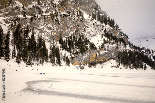 Wallpaper Mural Couple walking on frozen lake in snowy mountain landscape Torontodigital.ca