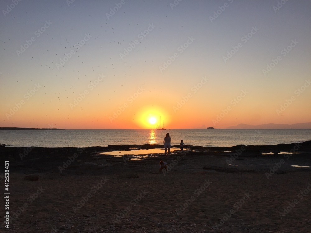 Atardecer con el cielo anaranjado y rosado en la playa cerca del mar de Formentera