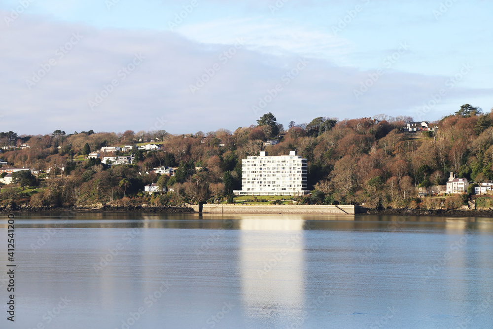 A view from Bangor across the  calm Menai Strait to buildings on Anglesey Island, Wales, UK.