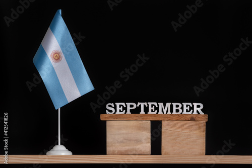 Wooden calendar of September with Argentine flag on black background. Holidays of Argentina in September.
