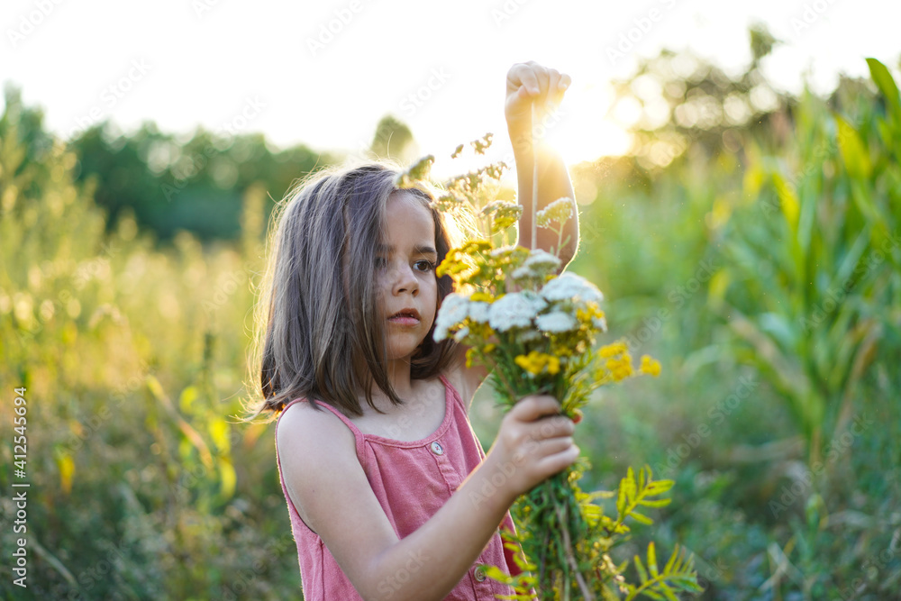 Portrait of a little girl with flowers in the field Portrait of a little girl with flowers in the field