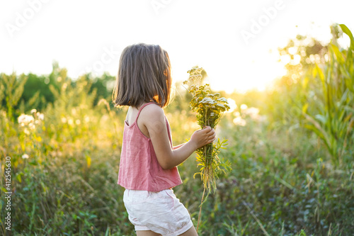 Portrait of a little girl with flowers in the field