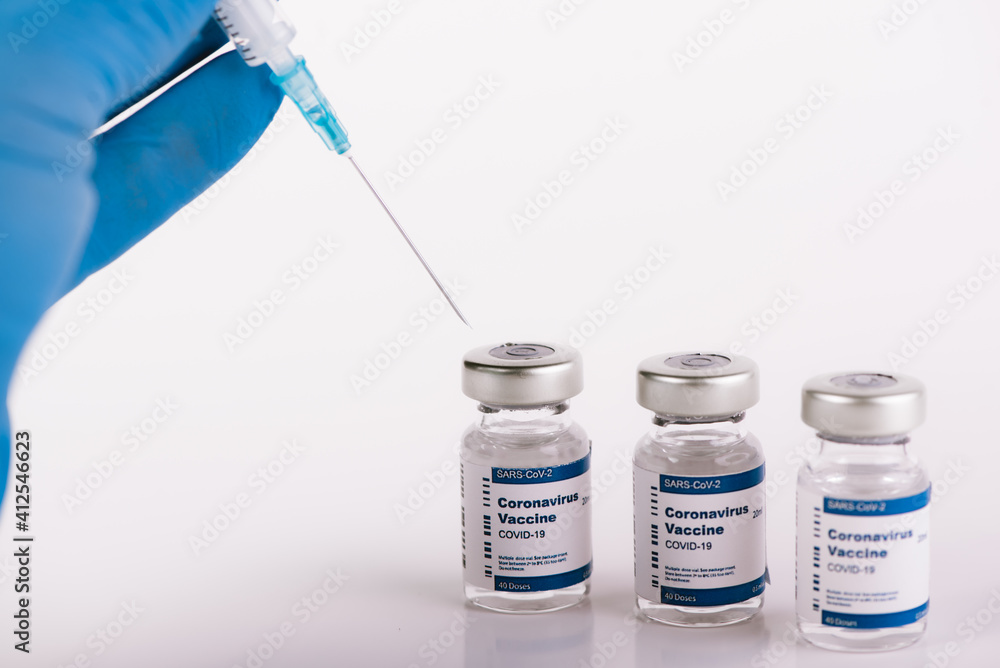 Blue latex glove hand with syringe taking anti covid vaccine Blue latex glove hand with syringe taking anti covid vaccine