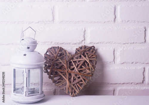 White candlestick with a wicker heart on a white background. concept for Valentine's Day, Mother's Day. space for text  photo