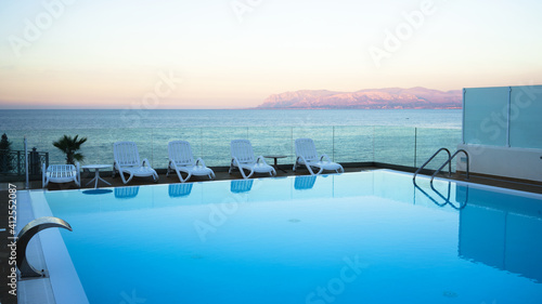 Beautiful swimming pool over the sea at sunset, Sicily, Italy