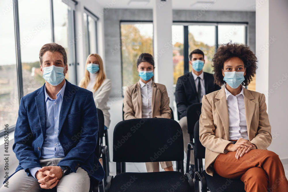 Group of multicultural business people with face masks sitting and listening presentation in corporate firm during corona virus. - obrazy, fototapety, plakaty 