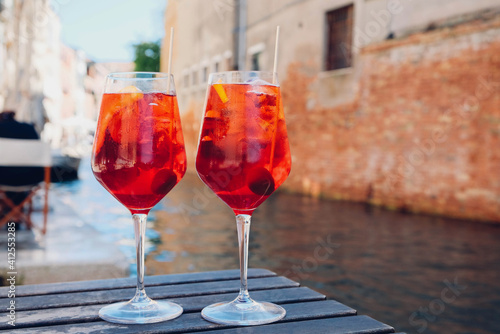 Two glasses of Spritz Veneziano cocktail served near the Venetian canal. Popular italian summer aperitif drink.