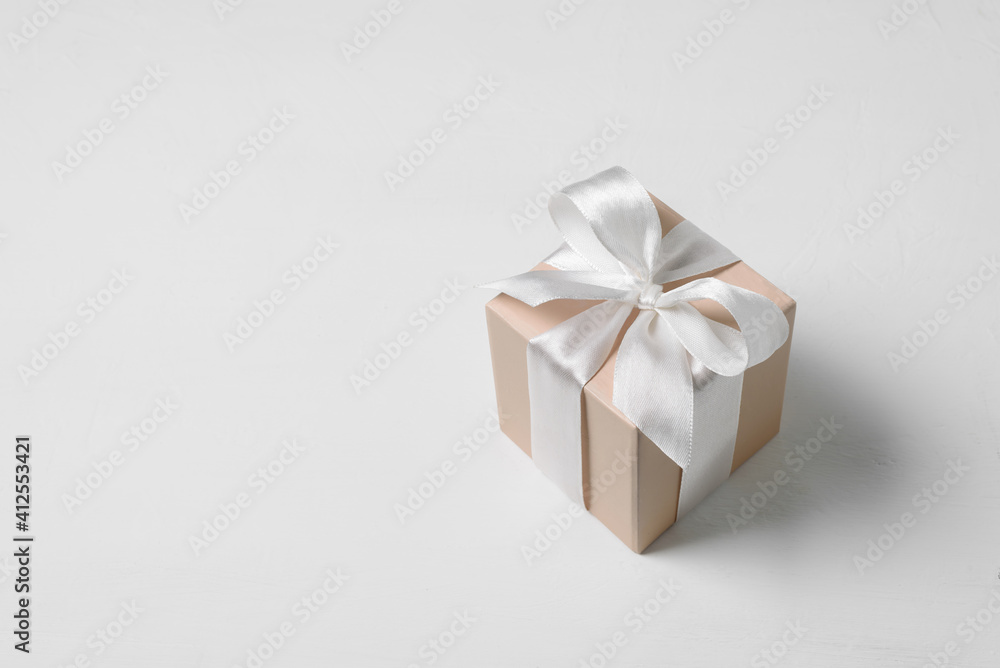 Beige gift box with bow on white background Beige gift box with bow on white background