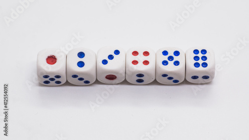 Heap of white cubic tree six dices with blue and red spikes  dots  on a white background. Game  gambling  chance and risk concept
