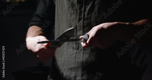 Close-up shot of chef sharpens knife for cooking, chef preparing his knife, 4k footage.