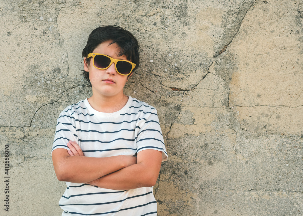 rebellious boy with sunglasses next to a wall rebellious boy with sunglasses next to a wall