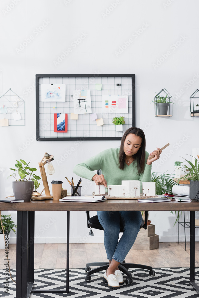 young african american architect making models of buildings while working at home studio young african american architect making models of buildings while working at home studio