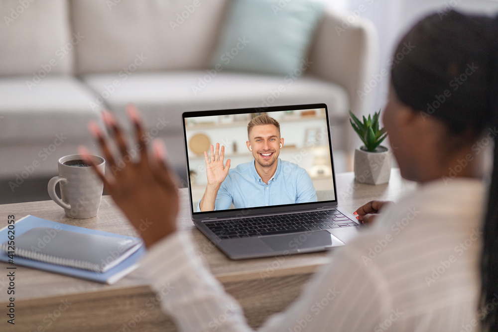 Black woman having video chat with young man on laptop