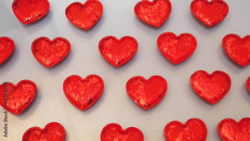 red hearts background. Many scarlet shiny hearts on a light background, backgrounds and textures red hearts background. Many scarlet shiny hearts on a light background, backgrounds and textures