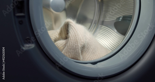 Close up of wool sweater in modern washing machine