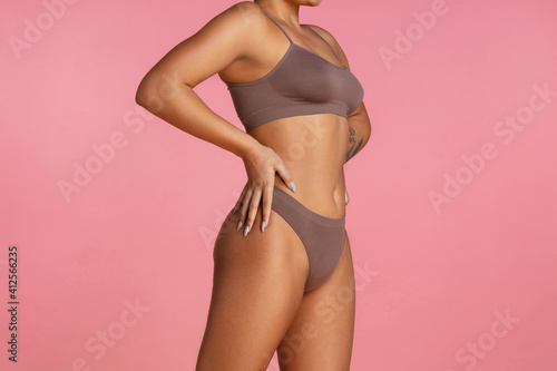 Belly. Beautiful body of young african-american woman isolated on pink studio background. Fit, healthy and strong authentical body. Natural beauty, treatment, healthcare, fitness and diet concept.