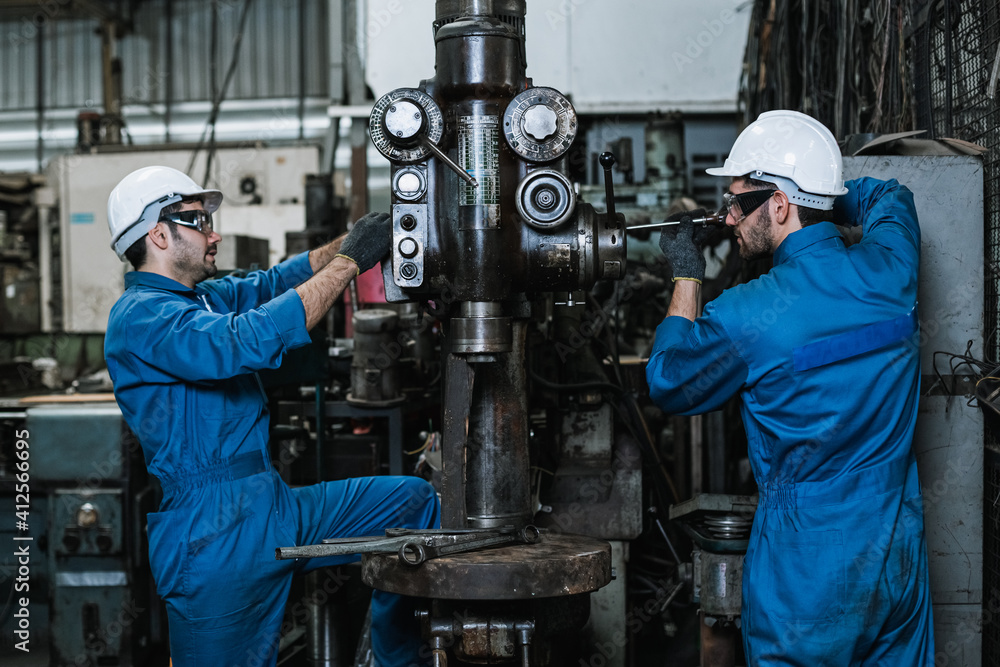 Engineering man wearing uniform safety workers perform maintenance in factory working machine lathe metal Engineering man wearing uniform safety workers perform maintenance in factory working machine lathe metal