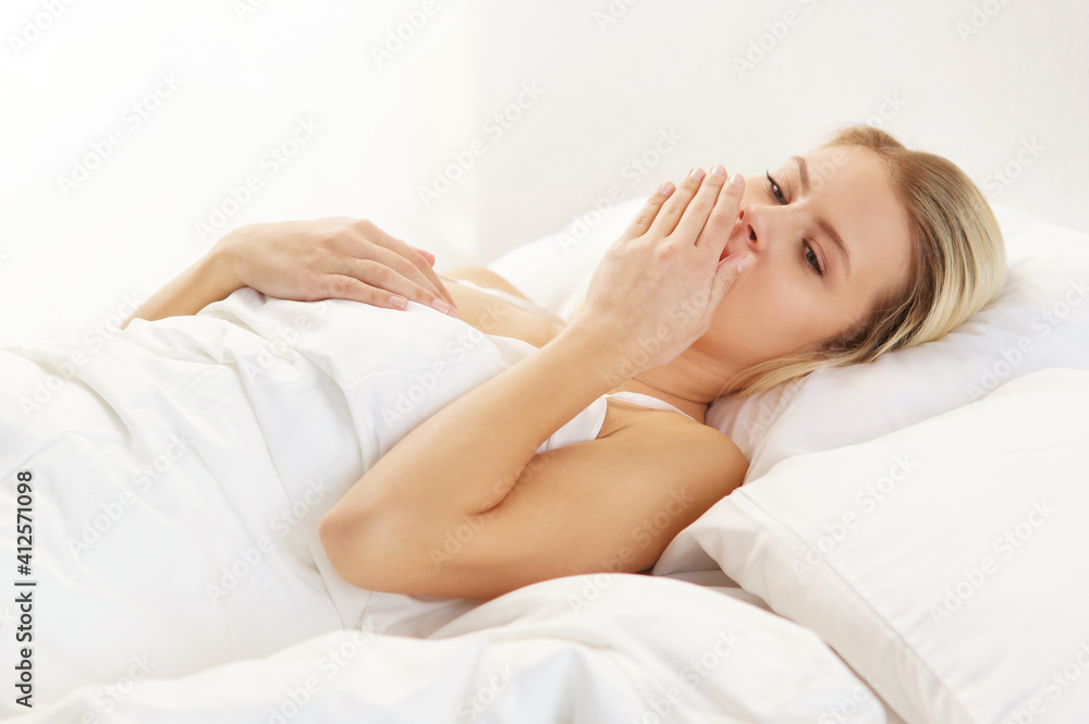 Young and beautiful blond girl in the bed. Sleeping woman in a rays of morning sun. Young and beautiful blond girl in the bed. Sleeping woman in a rays of morning sun.