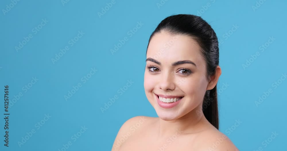 Beautiful woman with naked shoulders blowing a kiss and winking eye while touching her perfect skin Beautiful woman with naked shoulders blowing a kiss and winking eye while touching her perfect skin