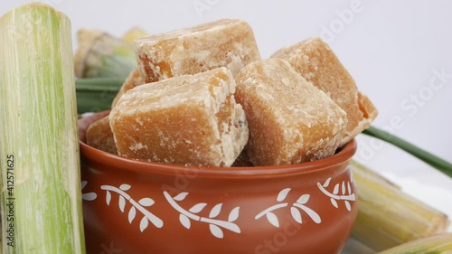 Rotating shot of red mud bowl filled with sugarcane jaggery ( gud )